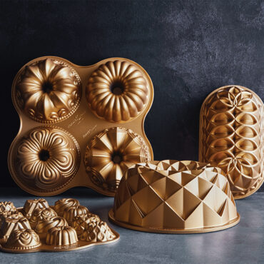 Nordic Ware gold aluminum baking pans collection featuring geometric bundt, loaf, and specialty molds