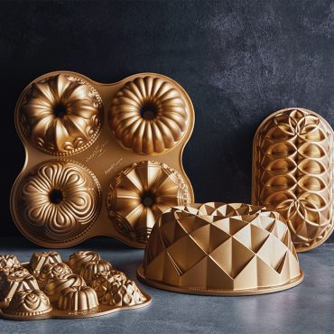 Collection of Nordic Ware gold aluminum bundt pans featuring Jubilee four-cavity pan with decorative fluted designs