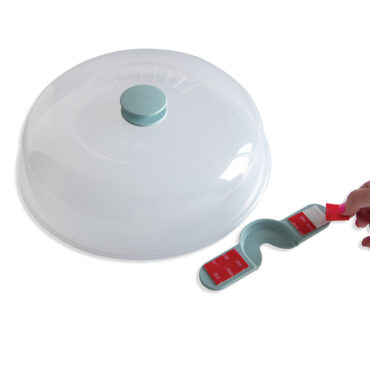 Person's hand peeling red protective strip from white wall-mounted storage bracket for spatter cover