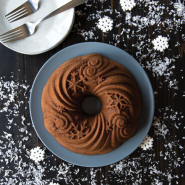 Golden bundt cake baked in Nordic Ware Let it Snow bundt pan, showing snowflake pattern design