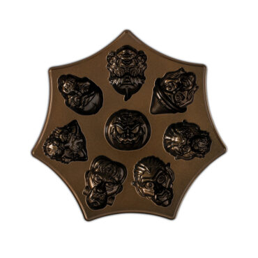 Nordic Ware aluminum Monster Mask Cakelet Pan, interior view showing 6 monster face-shaped cavities