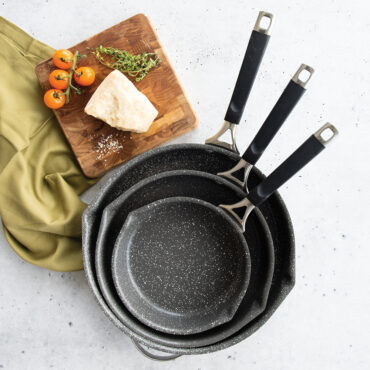 Three Nordic Ware Verde ceramic nonstick skillets in different sizes, sage green exterior with cream interior