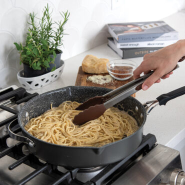 Nordic Ware Verde ceramic nonstick 12-inch skillet with cooked pasta and vegetables on stovetop