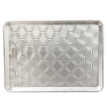 Nordic Ware aluminum half sheet pan with decorative starburst pattern embossed on bottom, natural silver finish
