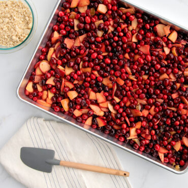 Nordic Ware aluminum rectangular baking pan filled with baked cranberry apple dessert, golden brown surface