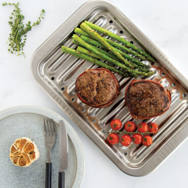 Nordic Ware natural aluminum broiler pan with slotted rack, roasted vegetables and meat visible