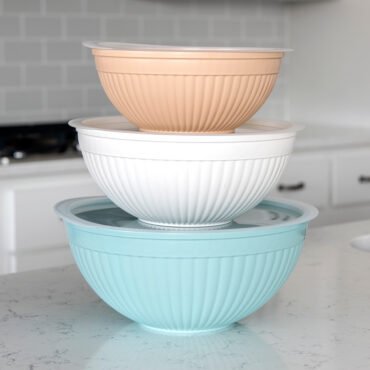 Nordic Ware white melamine mixing bowls with matching lids, six graduated sizes stacked in kitchen setting