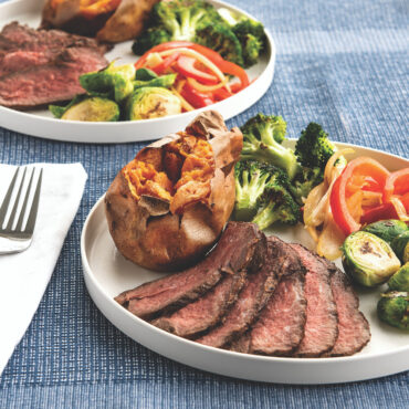 Two Nordic Ware aluminum meal plates with grilled steak and roasted vegetables, showing natural silver finish