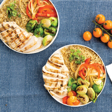 Nordic Ware white ceramic lunch plate with compartments holding colorful meal on blue placemat