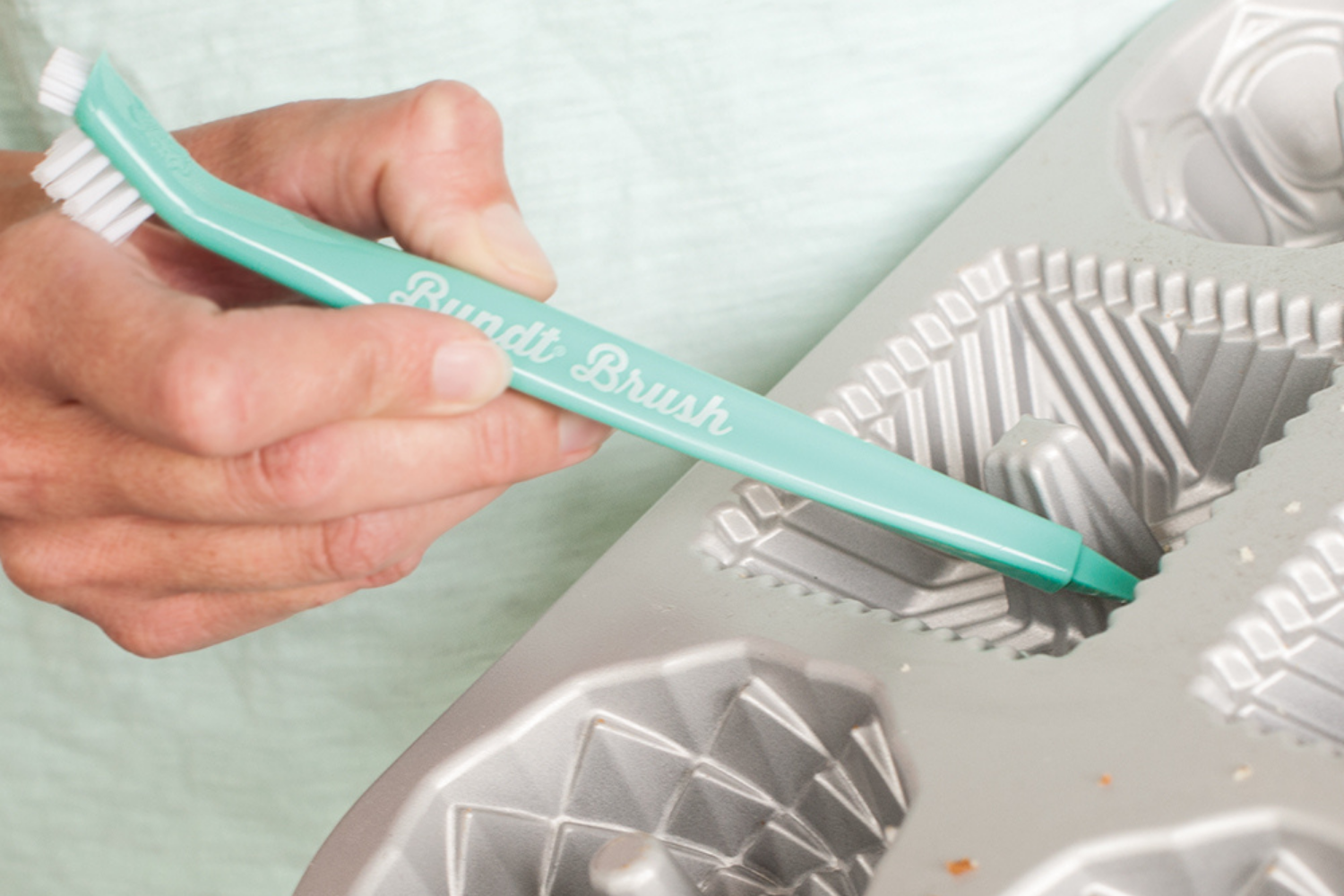 Cleaning a detailed Bundtlette® pan using the Bundt® cleaning tool. 