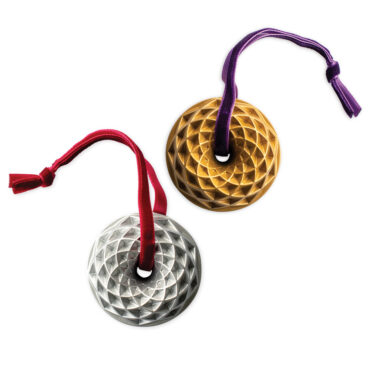 Two Nordic Ware miniature bundt pan ornaments, one gold and one silver, with detailed fluted ridges