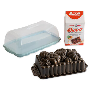 Nordic Ware aluminum Harvest Bounty loaf pan with decorative wheat design, clear plastic cake keeper, and pumpkin bread mix box