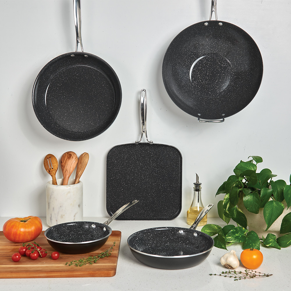 Nordic Ware Basalt 5-piece black non-stick cookware set with skillets and saucepans on marble countertop