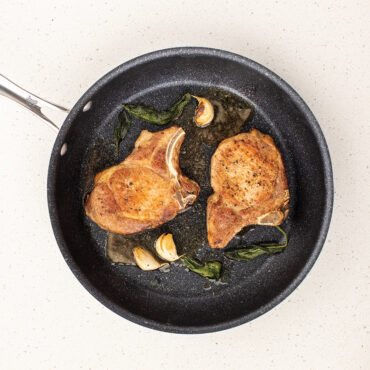 Nordic Ware Basalt ceramic nonstick 12-inch skillet with two golden-brown seared pork chops