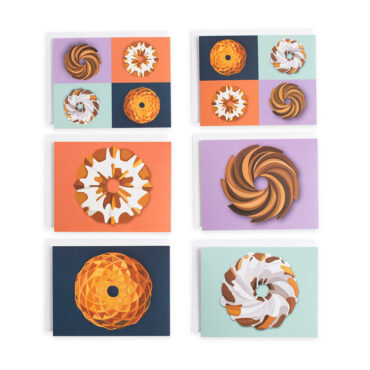 Five Nordic Ware bundt greeting cards fanned out showing colorful bundt cake designs and recipes