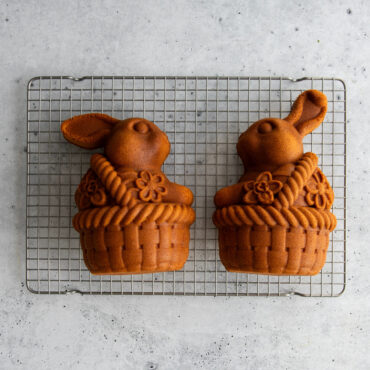 Two halves of golden-brown bunny-shaped cake from Nordic Ware 3D bunny in basket cake pan on cooling rack