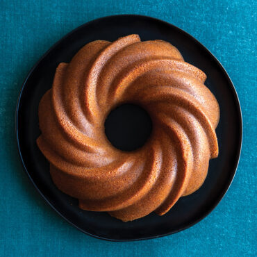 Nordic Ware aluminum Swirl Bundt pan with elegant spiral fluted design, silver finish, empty baking mold