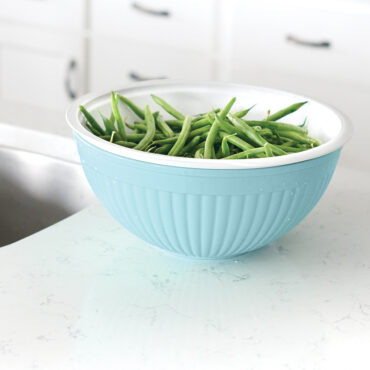 Nordic Ware white plastic colander nested in matching bowl, filled with fresh green beans