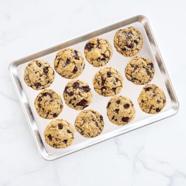 Nordic Ware aluminum half sheet baking pan with golden brown cookies, natural silver finish