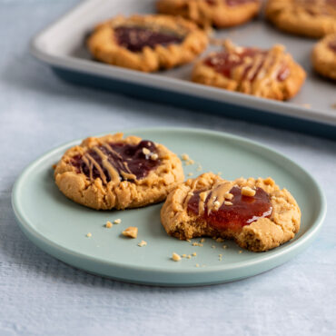 Nordic Ware aluminum half sheet pan with golden-brown peanut butter and jelly cookies arranged on surface