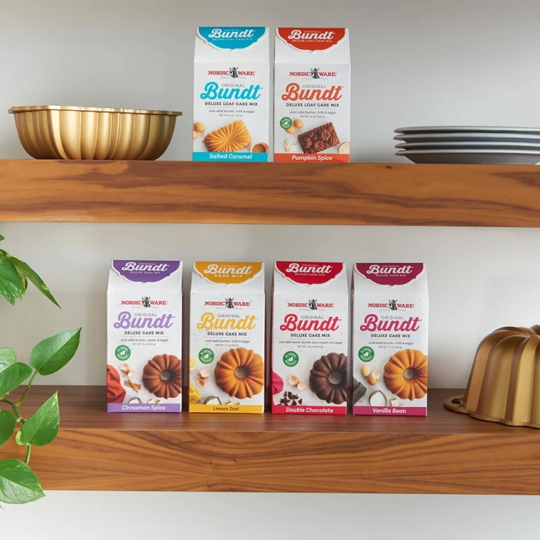 Image of kitchen shelves with Nordic Ware Bundt and Quick Bread Mix boxes on shelf with decor.