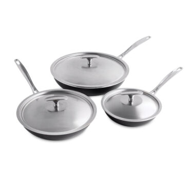 Nordic Ware Basalt 6-piece cookware set with three black skillets and matching glass lids arranged on white background