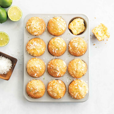 Nordic Ware nonstick muffin pan with 12 golden lemon poppy seed muffins, dark gray finish