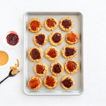 Nordic Ware nonstick half sheet pan with golden-brown peanut butter and jelly cookies arranged on surface