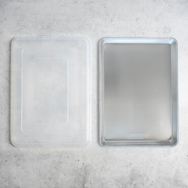 Nordic Ware aluminum Big Batch pan with fitted lid, rectangular natural silver cookware set shown separately