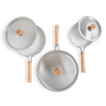 Nordic Ware Cardamom 6-piece nonstick frying pan set with lids in cream color on white background