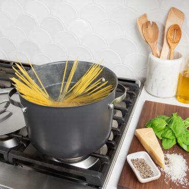 8qt Stock Pot with Lid on stovetop with uncooked spaghetti