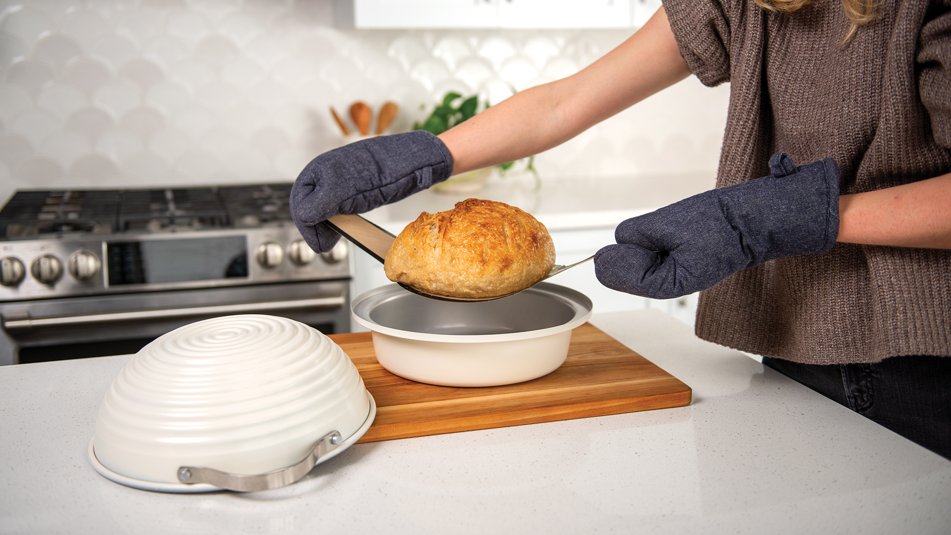 Removing a baked loaf of bread from the Simply Sourdough Bread Baker.