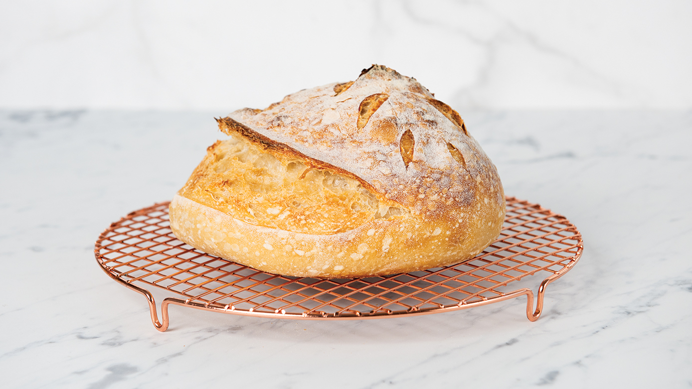 Image of baked sourdough loaf on a cooling rack