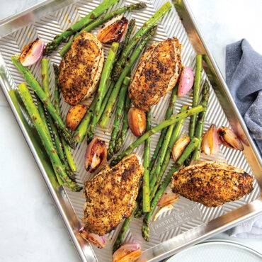 Nordic Ware Prism aluminum half sheet pan with golden roasted chicken and asparagus spears