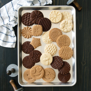 Golden baked cookies arranged on Nordic Ware Prism aluminum half sheet pan with textured diamond pattern surface