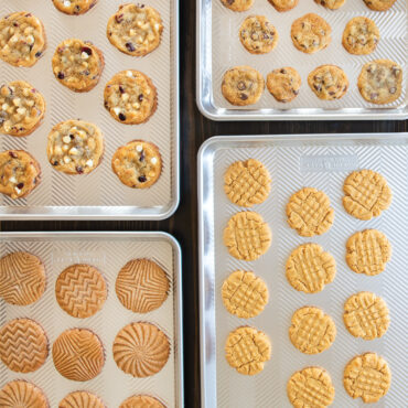 Assorted cookies and baked goods on Nordic Ware Prism aluminum sheet pans with geometric textured surface