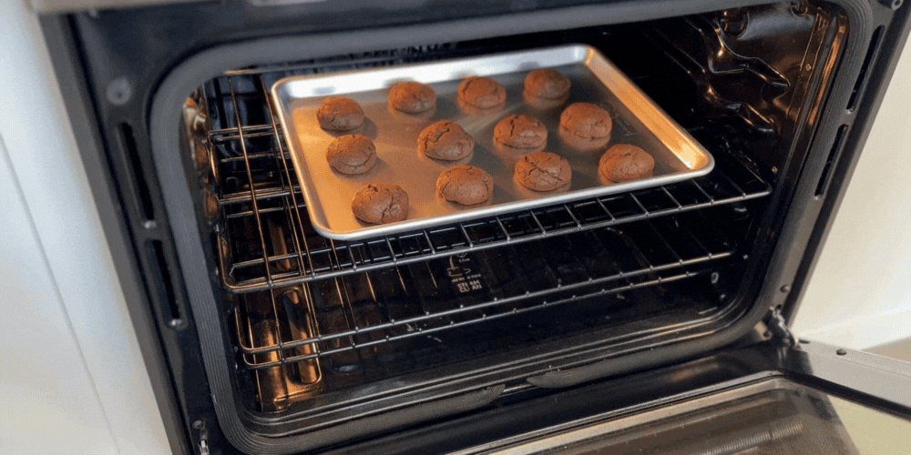Chocolate cookies being taken out of the oven on Nordic Ware Naturals® Half Sheet