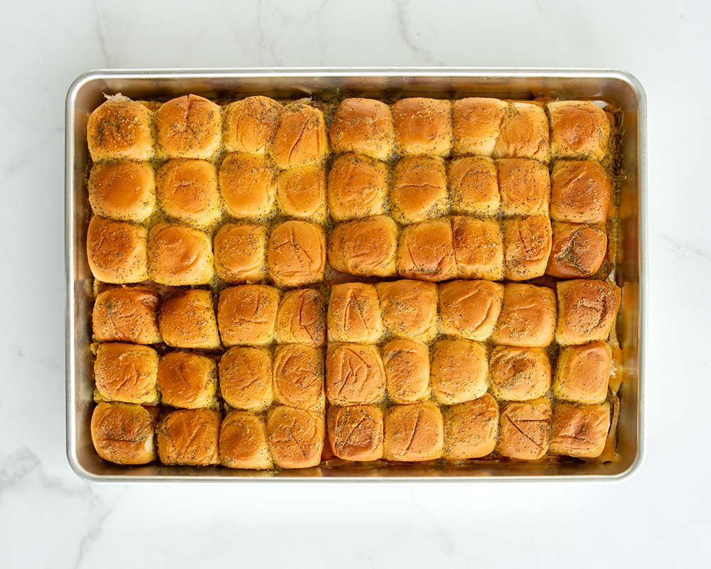 54 baked Ham and Cheese Sliders in the Naturals® Big Batch Pan.