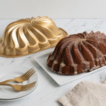 Pirouette Loaf cake glazed on plate next to pan, plate with two forks
