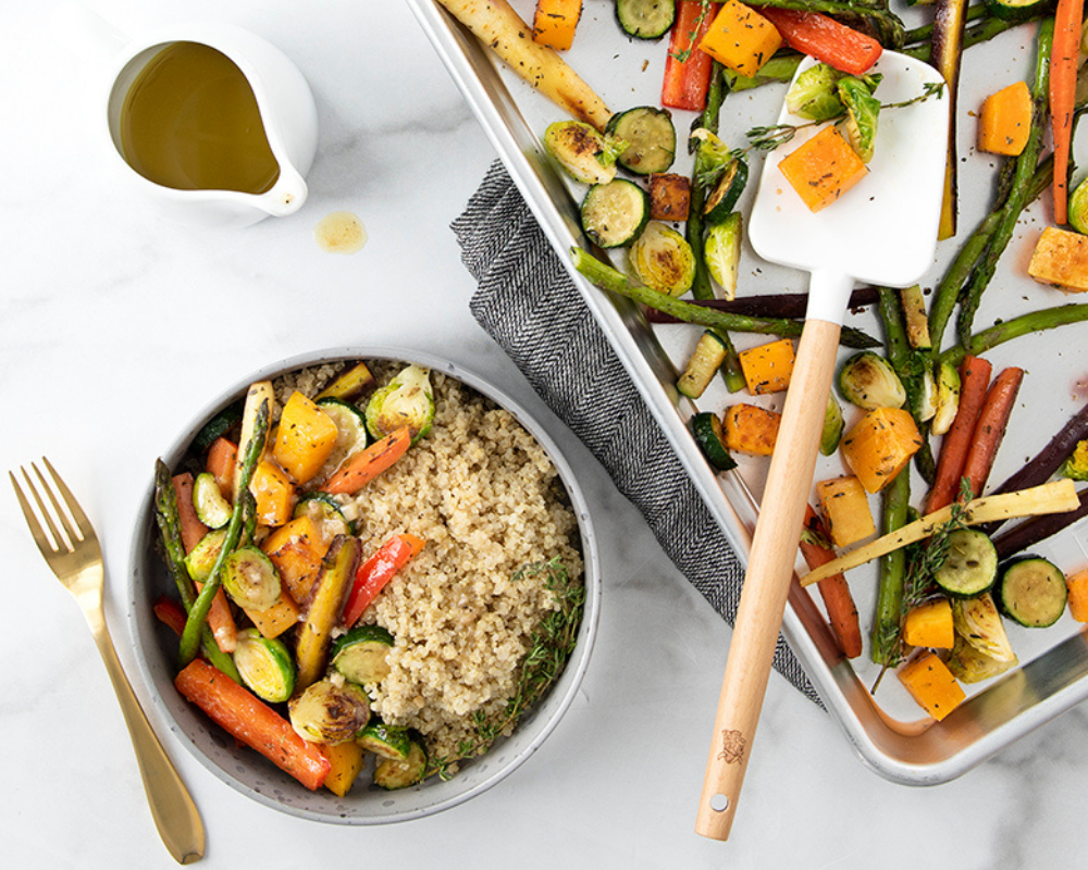 Roasted Herb Vegetables and Quinoa Bowl With Honey Mustard Dressing on a Naturals Baking Sheet and served in a small bowl.