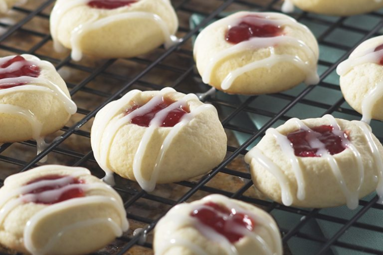 Strawberry Filled Butter Cookies with Lemon Glaze on a wire cooling grid.