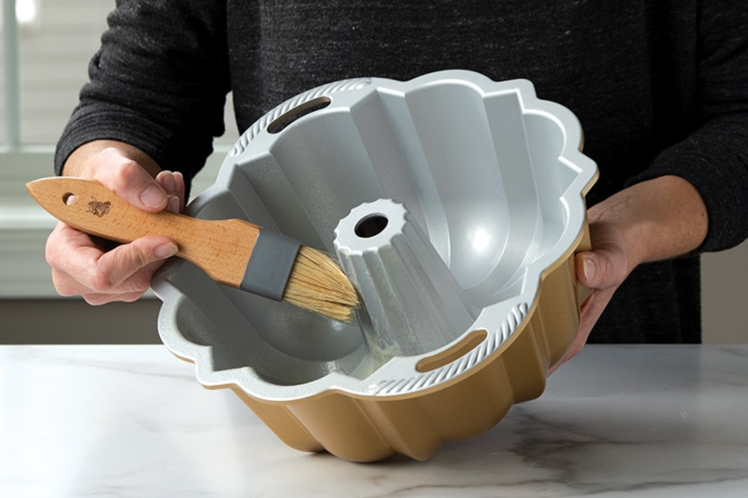 Person prepping a Bundt pan with a pastry brush
