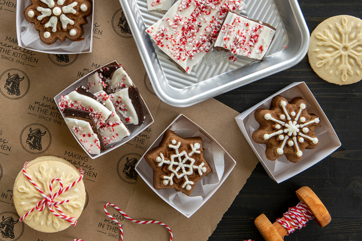 Peppermint bark, stamped snowflake cookies, and snowflake cakelets wrapped and packaged for holiday gifts.