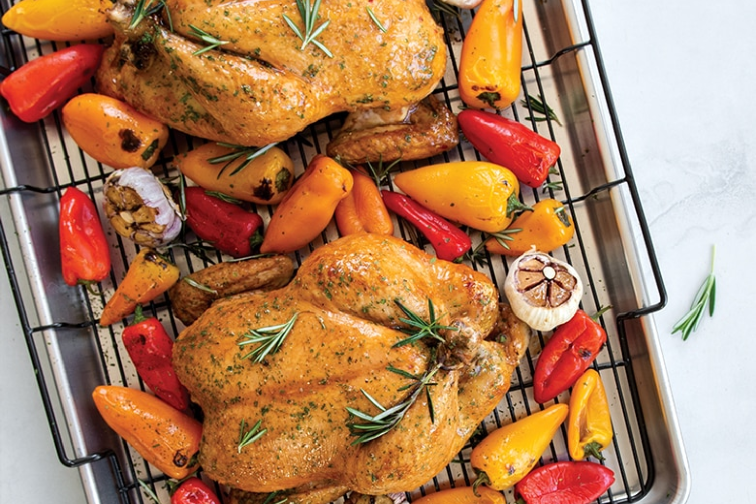 Two baked chickens and peppers on a Extra Large Oven Crisp Baking Tray.