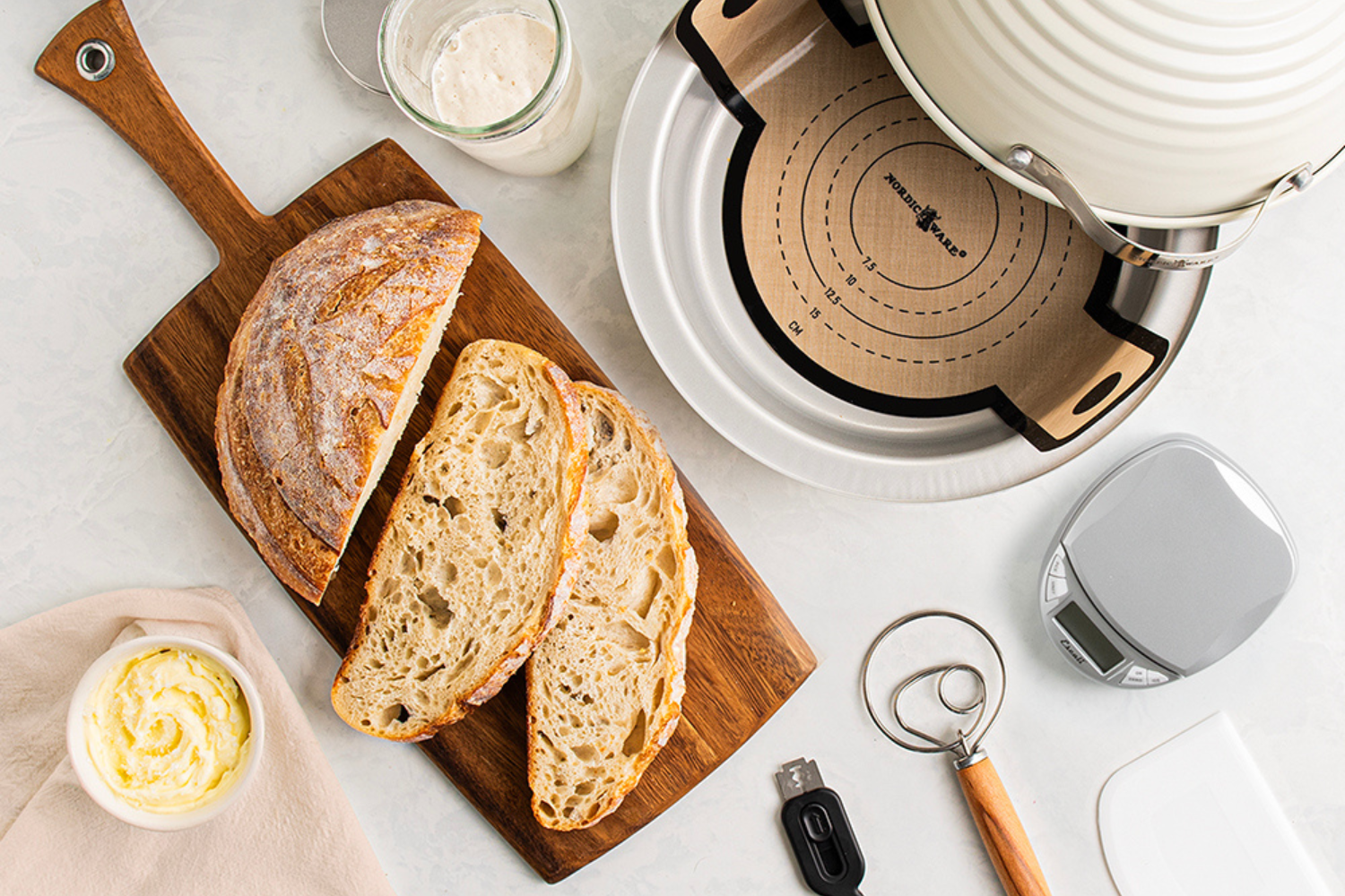 Simply Sourdough Bread Baking Kit overhead shot with sliced bread on a cutting board and a bowl of butter.