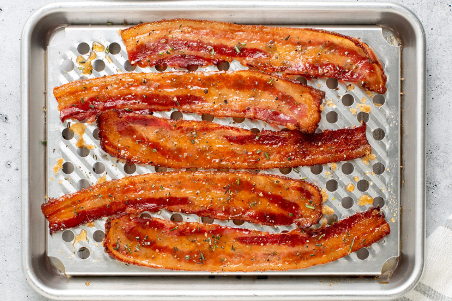 Naturals® Quarter Sheet with Multi-Task Oven & Cooling Rack with perfectly cooked bacon on it.