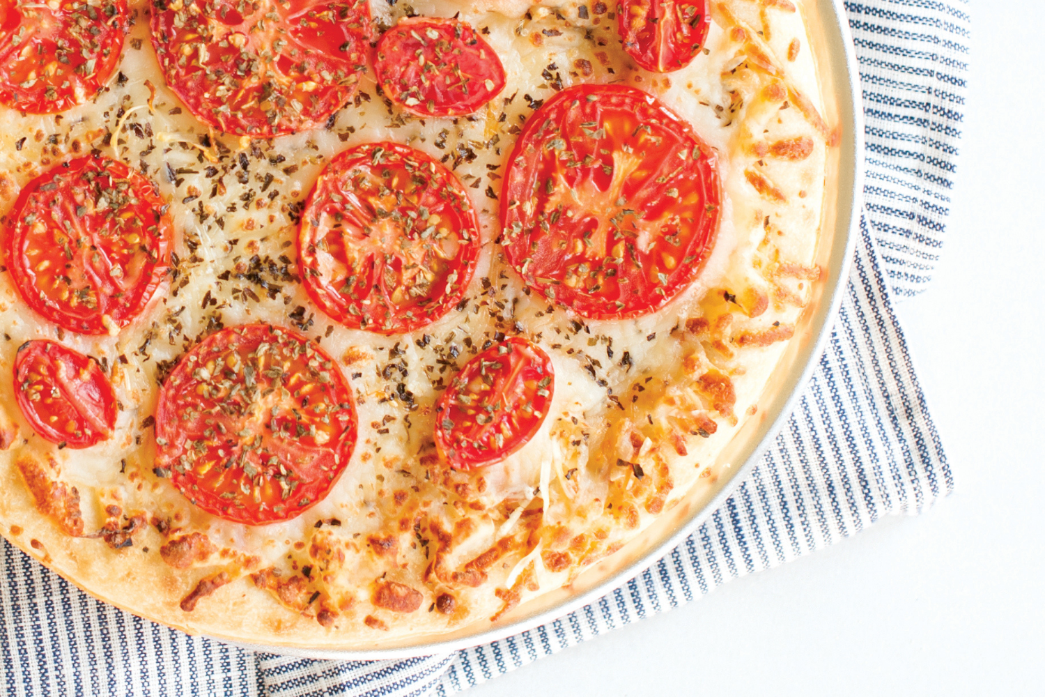 Naturals® 9" Hot Air Pizza Crisper with a white pizza with tomatoes baked on it.