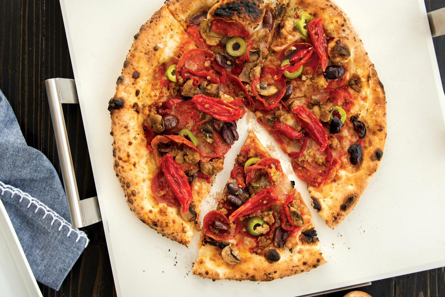 Deluxe Square Pizza Stone with Rack with supreme pizza baked on it.