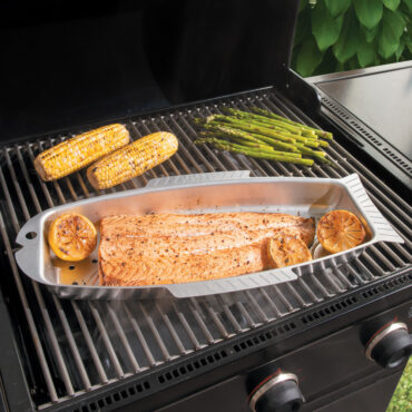 nordic ware seafood griller with salmon and lemon being cooked on grill with corncobs and asparagus