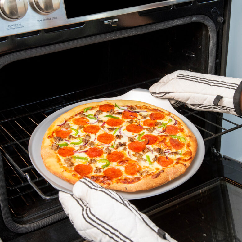  Image of sourdough pizza crust recipe with supreme toppings coming out of the oven on Nordic Ware Pizza and Baking Steel